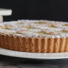 Una deliziosa crostata di ricotta, cosparsa di zucchero a velo, pronta per essere gustata.