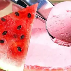 Una fetta di cocomero succoso accanto a una pallina di gelato al cocomero rosa, pronta per essere gustata.