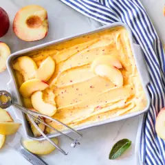Sorbetto alla pesca fatto in casa, con pesche fresche e un cucchiaio per servirlo. Un dolce estivo rinfrescante.