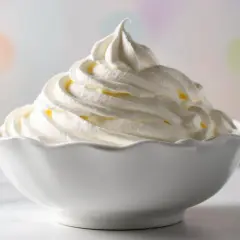 Panna fresca per dolci fatta in casa, montata a neve in una ciotola bianca, pronta per guarnire torte e dessert.