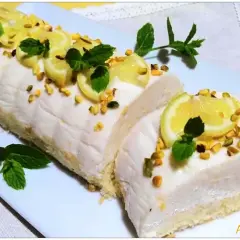 Delizia al limone: rotolo soffice con crema al limone, guarnito con fettine di limone, pistacchi e menta.