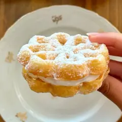 Un delizioso bacio pantesco, un dolce ripieno di crema, cosparso di zucchero a velo, pronto per essere gustato.