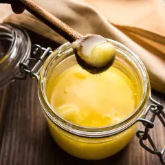 Un cucchiaio di burro chiarificato dorato, pronto per la tua ricetta.