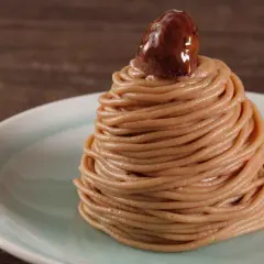 Un delizioso montblanc dolce, un dolce di castagne a forma di cono, guarnito con una castagna lucida.