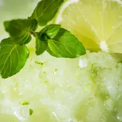 Granita alla menta fatta in casa, rinfrescante e profumata, guarnita con menta fresca e una fetta di lime.