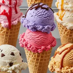 Una selezione di coni gelato colorati, tra cui cioccolato, fragola, vaniglia con gocce, caramello e viola. Questi sono alcuni dei gusti di gelato più mangiati.