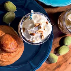 Deliziosa granita di mandorle con latte di mandorla, guarnita con mandorle a lamelle, accompagnata da un pane dolce e mandorle verdi.