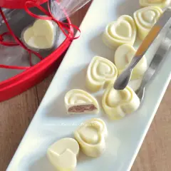 Cuori di cioccolato fatto in casa con cacao, ripieni e pronti per essere gustati.