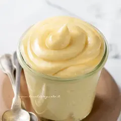 Deliziosa crema chiboust in un vasetto, pronta per essere gustata con due cucchiaini d'argento.