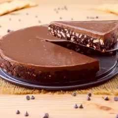 Una fetta di torta fredda con biscotti e cioccolato viene sollevata da una tortiera.