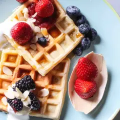 Waffle ricetta originale belga con fragole, mirtilli, more, panna e mandorle.