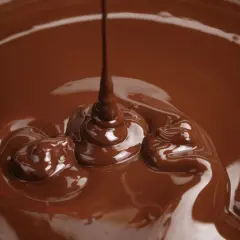 Cioccolato fuso che cola, un'immagine perfetta per spiegare come sciogliere il cioccolato nel microonde.