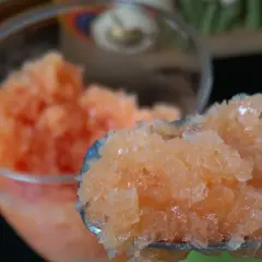 Granita all'arancia fatto in casa da Benedetta, fresca e dissetante, servita in un bicchiere e su un cucchiaio.