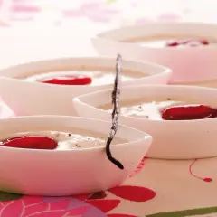 Deliziosa crema di riso in ciotoline bianche, guarnita con bacche rosse e un baccello di vaniglia.