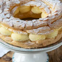 Un delizioso Paris Brest, un anello di pasta choux ripieno di crema pasticcera e guarnito con mandorle e zucchero a velo.