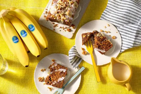 Fette di banana bread senza uova, guarnite con glassa e noci, pronte per essere gustate.