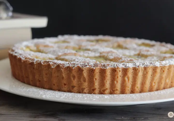 Una deliziosa crostata di ricotta, cosparsa di zucchero a velo, pronta per essere gustata.
