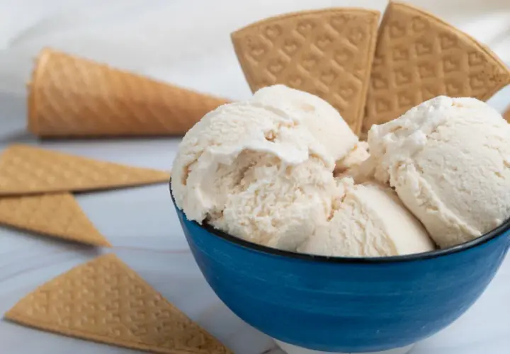 Coppetta blu con gelato fiordilatte cremoso, circondata da coni e cialde. Gli ingredienti base per un piacere semplice.
