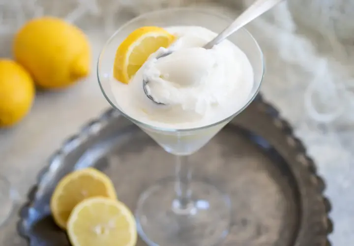 Sorbetto limone senza albume, fresco e dissetante, servito in coppa con spicchi di limone.