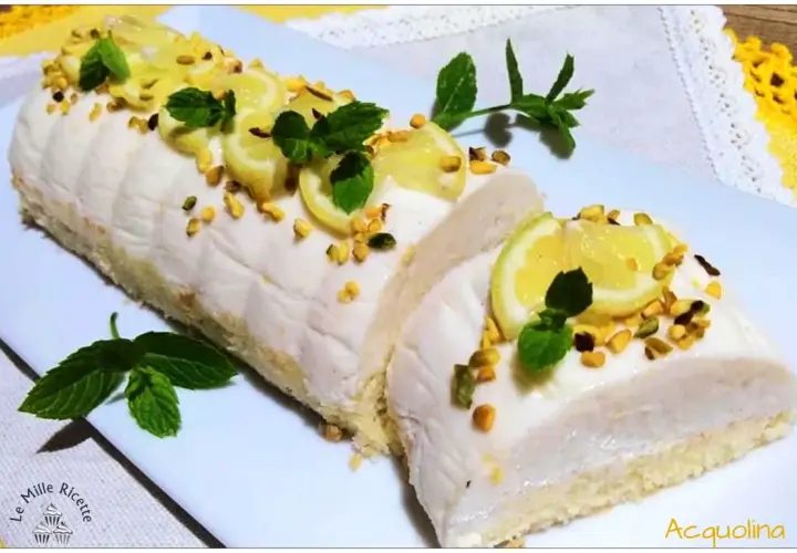 Delizia al limone: rotolo soffice con crema al limone, guarnito con fettine di limone, pistacchi e menta.