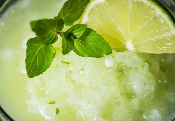 Granita alla menta fatta in casa, rinfrescante e profumata, guarnita con menta fresca e una fetta di lime.