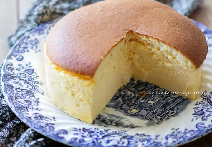 Una soffice torta giapponese, dorata in superficie e chiara all'interno, servita su un piatto decorato con un paesaggio in stile antico.