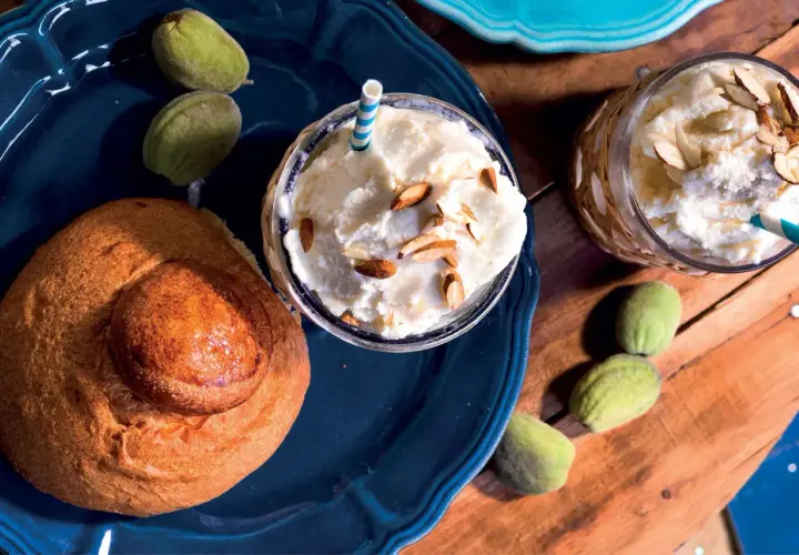 Deliziosa granita di mandorle con latte di mandorla, guarnita con mandorle a lamelle, accompagnata da un pane dolce e mandorle verdi.