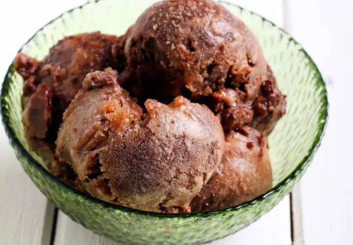 Coppa di sorbetto al cioccolato, con palline scure e invitanti, servite in una ciotola verde smeraldo.