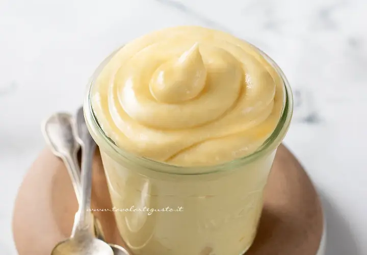 Deliziosa crema chiboust in un vasetto, pronta per essere gustata con due cucchiaini d'argento.