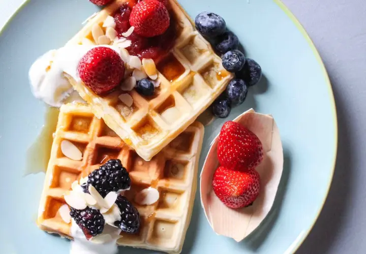 Waffle ricetta originale belga con fragole, mirtilli, more, panna e mandorle.