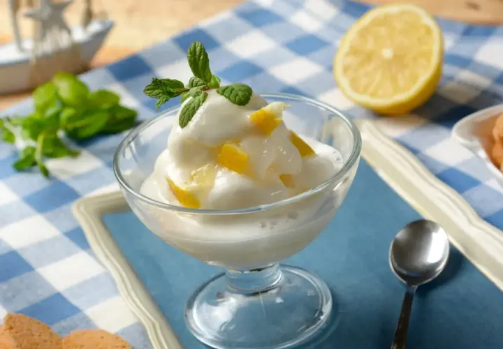 Sorbetto al limone, fresco e cremoso, preparato con la gelatiera, guarnito con menta e scorzette.
