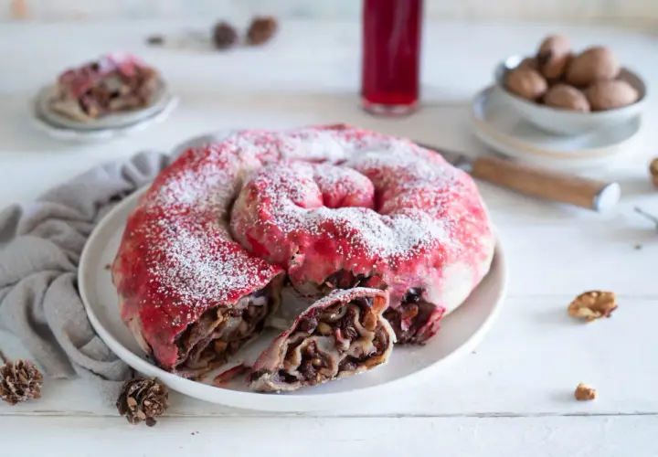 Dolce a spirale con ripieno di frutta e noci, spolverato di zucchero a velo, ricorda una rocciata umbra.