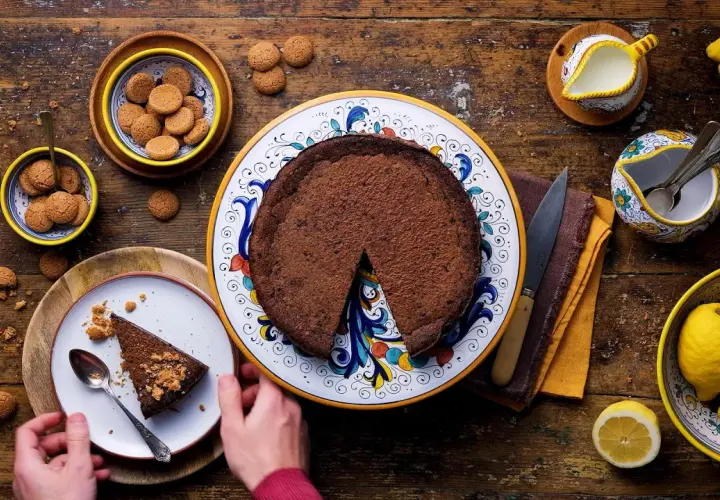 Una fetta di crescionda spoletina, ricca e cioccolatosa, pronta per essere gustata con amaretti e limoni freschi.