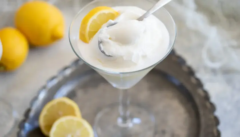 Sorbetto limone senza albume, fresco e dissetante, servito in coppa con spicchi di limone.