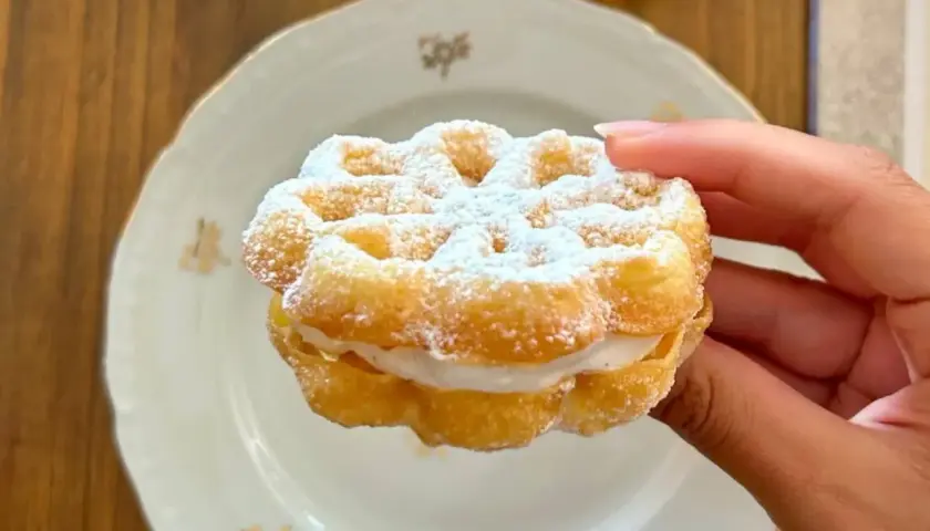 Un delizioso bacio pantesco, un dolce ripieno di crema, cosparso di zucchero a velo, pronto per essere gustato.