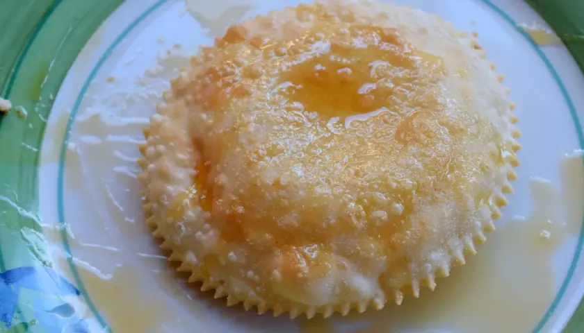 Un dolce sardo fritto, dorato e croccante, nappato con miele dorato.