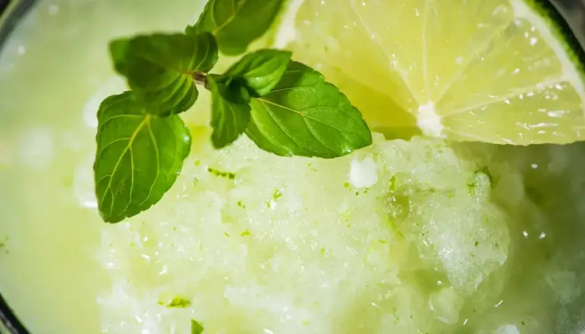 Granita alla menta fatta in casa, rinfrescante e profumata, guarnita con menta fresca e una fetta di lime.