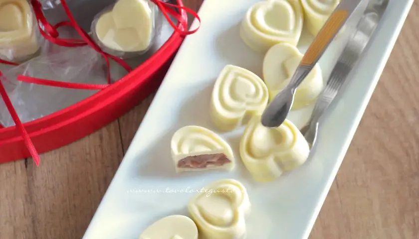 Cuori di cioccolato fatto in casa con cacao, ripieni e pronti per essere gustati.