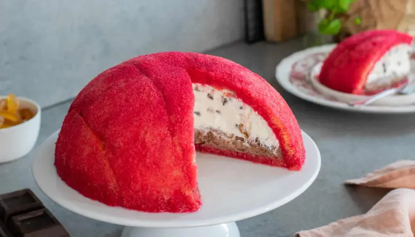 Un goloso zuccotto fiorentino, con pan di Spagna rosso e ripieno cremoso, pronto per essere gustato.