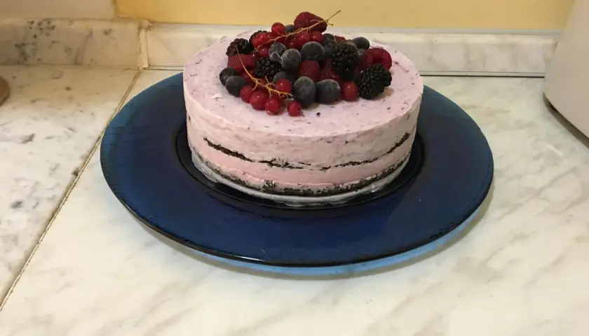 Torta gelato con base di biscotti secchi, guarnita con frutti di bosco freschi e congelati.