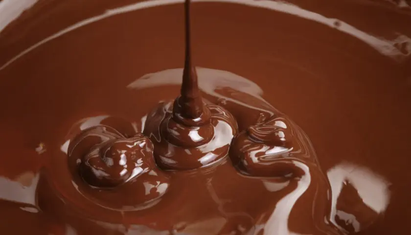 Cioccolato fuso che cola, un'immagine perfetta per spiegare come sciogliere il cioccolato nel microonde.