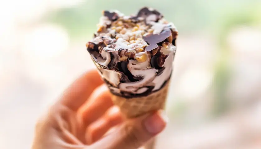 Cono gelato con panna, cioccolato e nocciole. Attenzione, il gelato è lassativo!