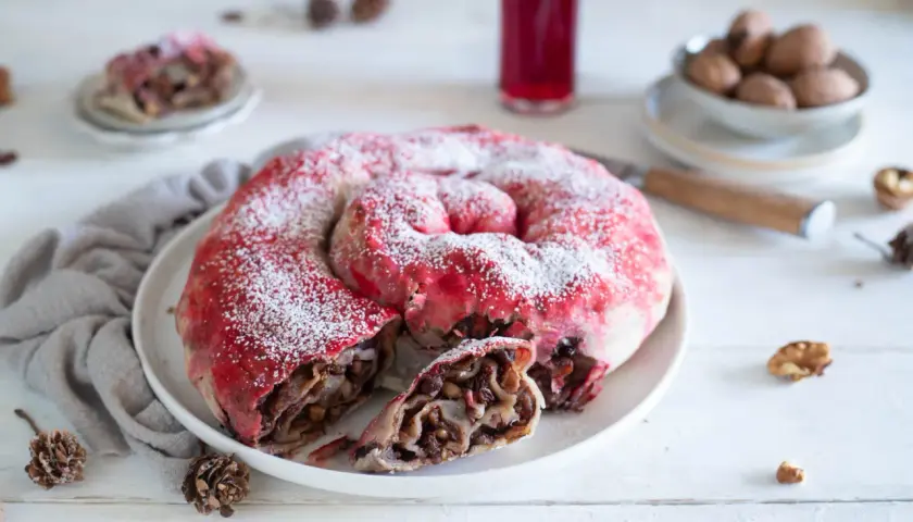 Dolce a spirale con ripieno di frutta e noci, spolverato di zucchero a velo, ricorda una rocciata umbra.