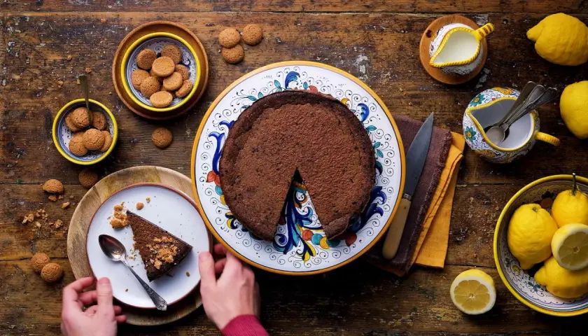Una fetta di crescionda spoletina, ricca e cioccolatosa, pronta per essere gustata con amaretti e limoni freschi.