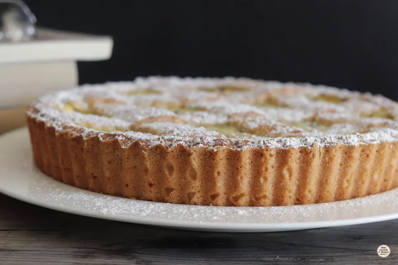 Una deliziosa crostata di ricotta, cosparsa di zucchero a velo, pronta per essere gustata.