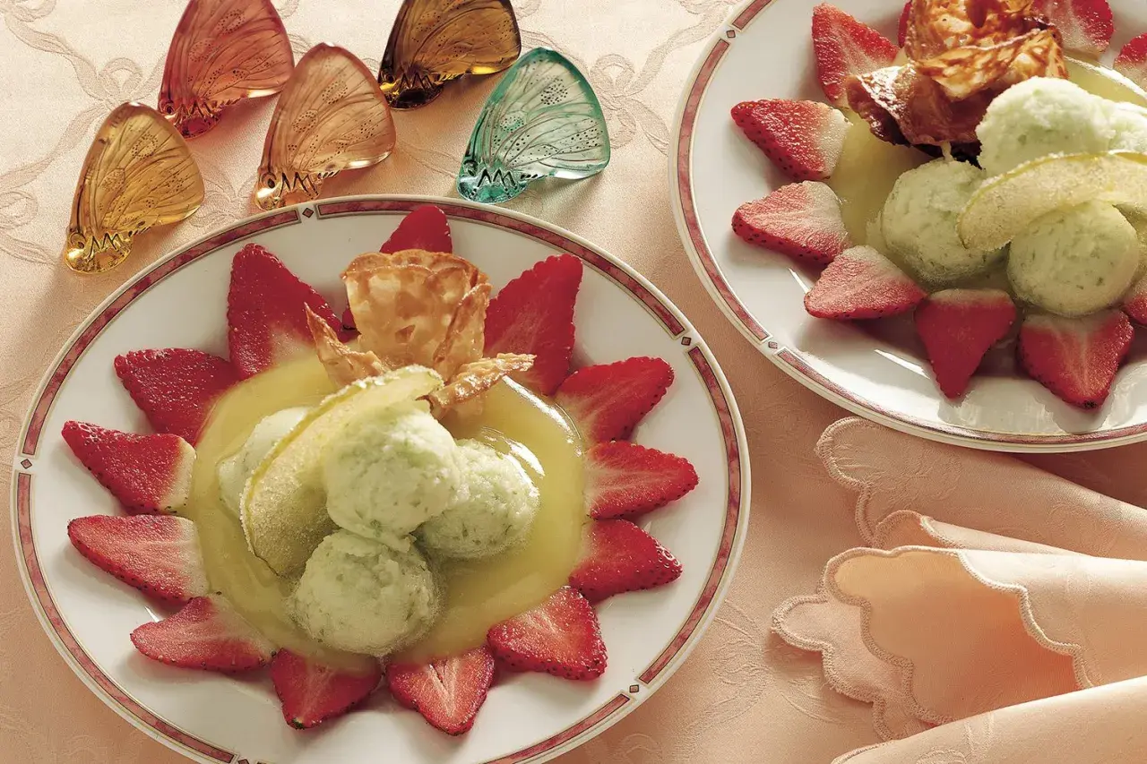Delizioso sorbetto di mela servito con fragole fresche e una cialda croccante.