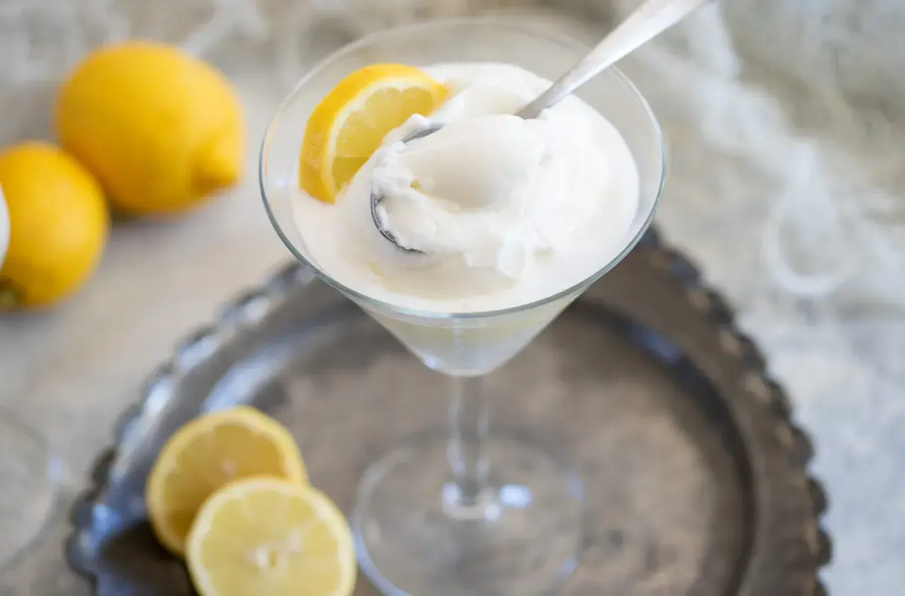Sorbetto limone senza albume, fresco e dissetante, servito in coppa con spicchi di limone.