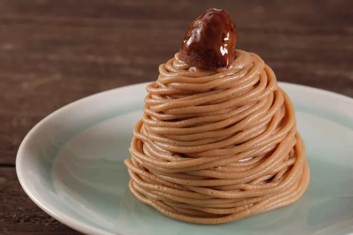 Un delizioso montblanc dolce, un dolce di castagne a forma di cono, guarnito con una castagna lucida.