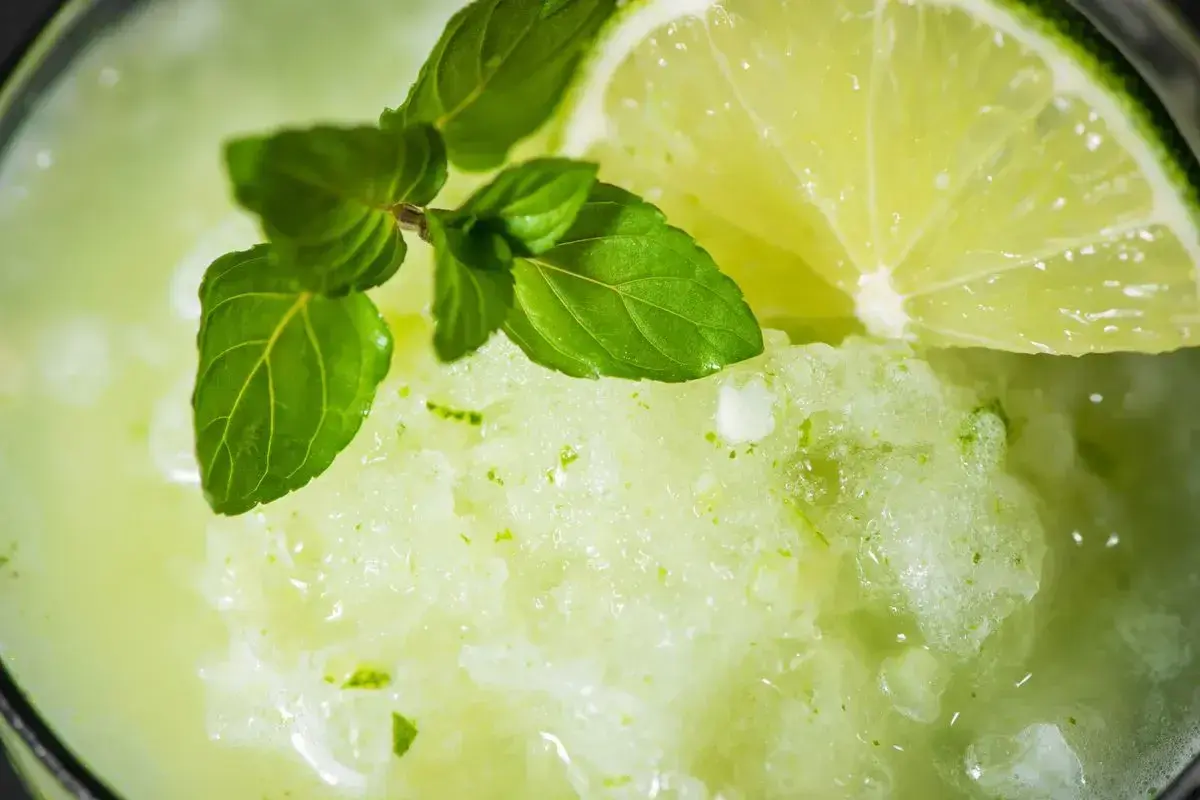 Granita alla menta fatta in casa, rinfrescante e profumata, guarnita con menta fresca e una fetta di lime.