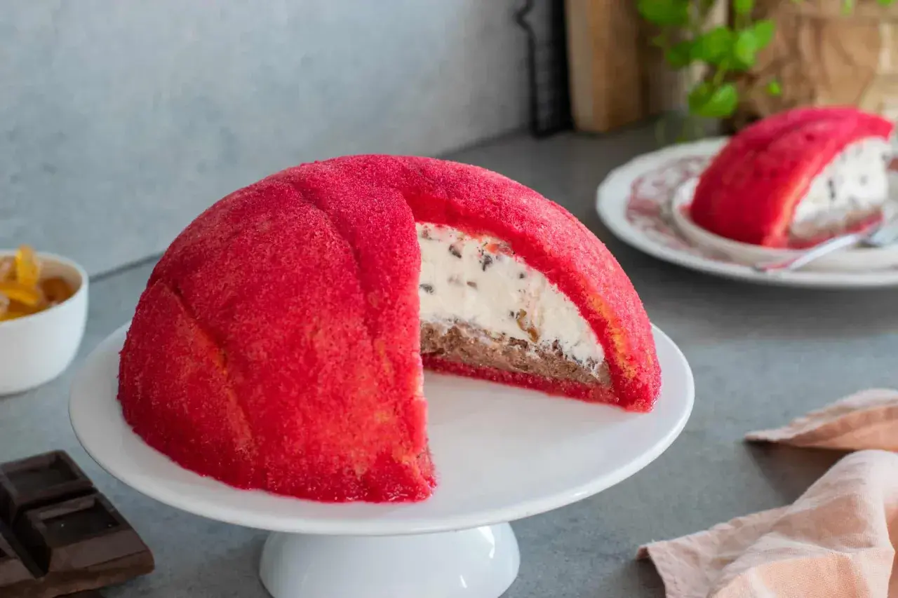 Un goloso zuccotto fiorentino, con pan di Spagna rosso e ripieno cremoso, pronto per essere gustato.